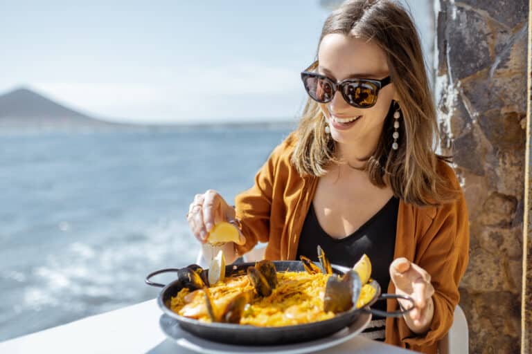 woman eating sea food near the ocean