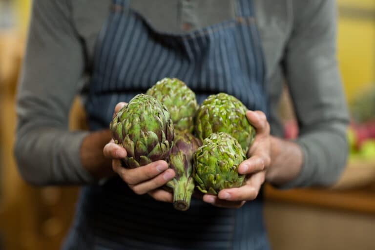 vendor holding custard apples at the grocery store