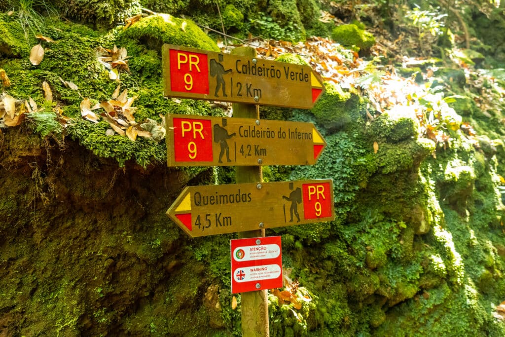 signs on the trekking trail next to the waterfall in levada do caldeirao verde, queimadas, madeira