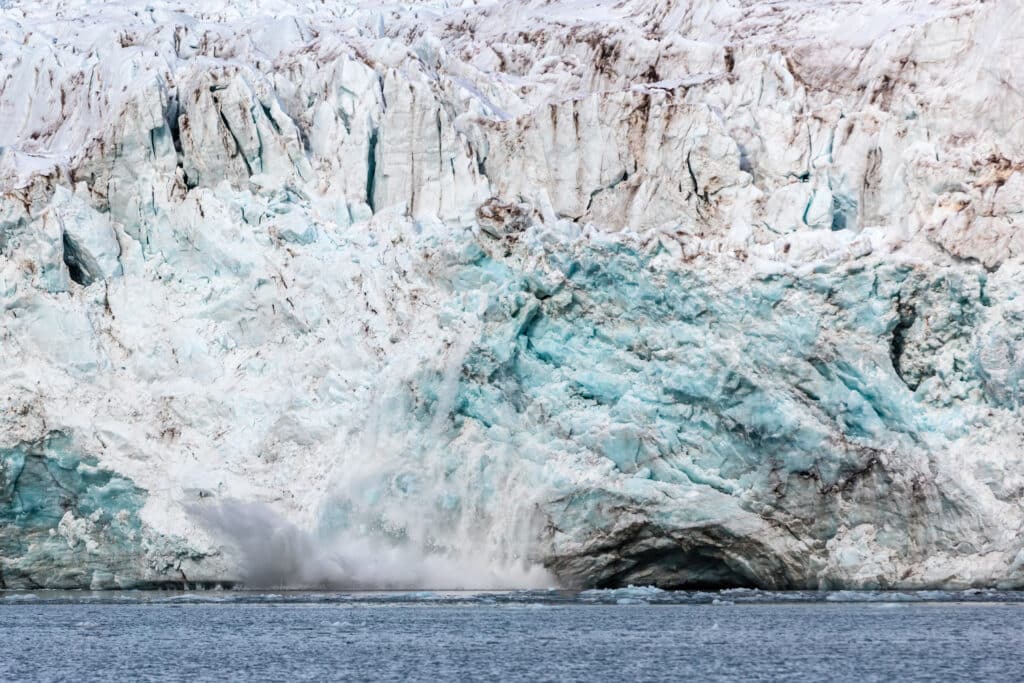 calving ice of a massive glacier at svalbard