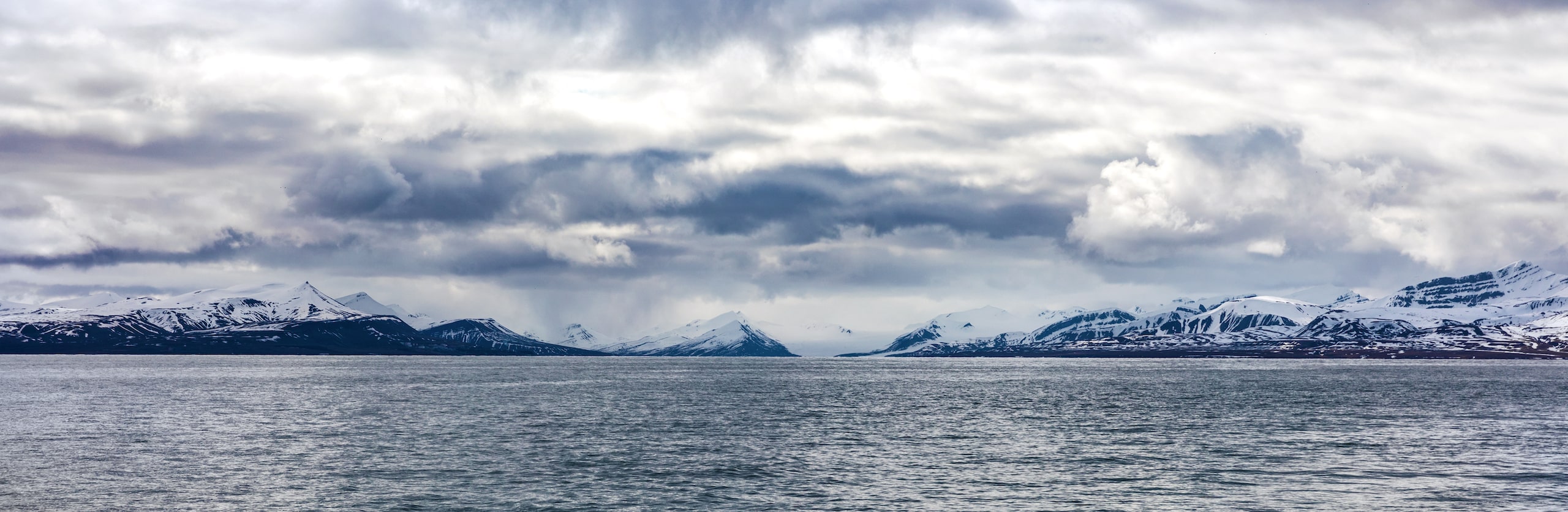 panorama of clouds over snowy mountains in the arctic